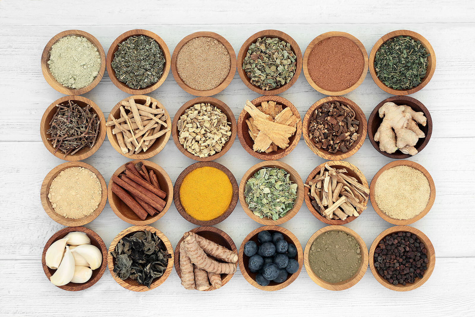 Assorted spices in bowls on wooden surface.