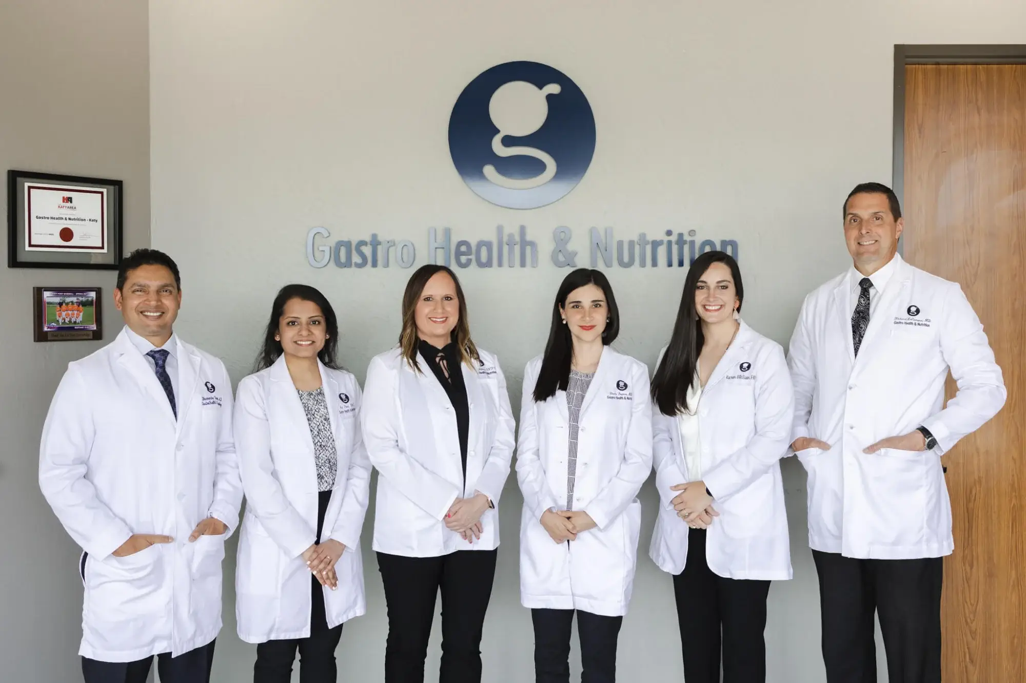 Medical team in white coats posing together.